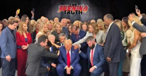 a group of people around Trump praying